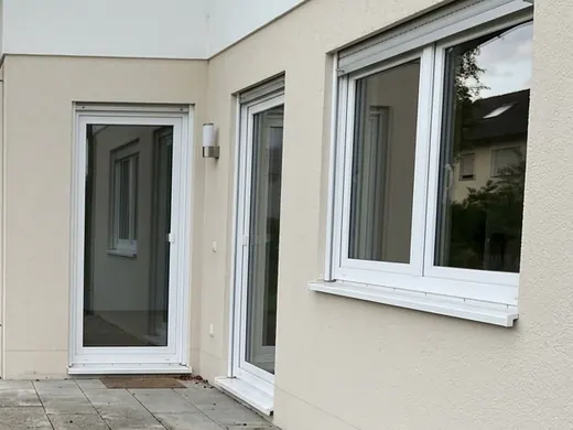 Symbolbild: Hauswand mit Fenster und Terrassentür aus der Nähe