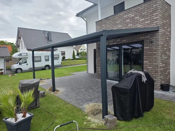 Alu-Terrassendach mit Glas am Wohnhaus mit Klinkerwand